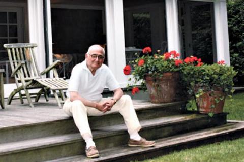 The architect is seen on the stadium steps at the back of the house, which looks out on the garden.